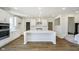 Modern kitchen featuring white cabinetry, a center island, stainless steel appliances, and wood-look flooring at 3241 Fawn Cir, Brownsburg, IN 46112