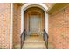 Inviting brick entryway with a gray front door, stone archway, iron railings and a cozy welcome mat at 328 Millridge Dr, Indianapolis, IN 46290