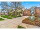 Brick home showcasing a spacious driveway, mature trees, landscaped lawn and manicured shrubs enhancing curb appeal at 328 Millridge Dr, Indianapolis, IN 46290