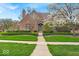 Charming brick home featuring manicured landscaping and a blossoming tree in a well-maintained front yard at 328 Millridge Dr, Indianapolis, IN 46290