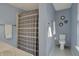 Bright blue bathroom with white tile floors, a bathtub with shower and decorative round mirrors on the wall at 3341 Suffolk Ct, Greenwood, IN 46143
