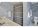 Bright blue bathroom with white tile floors, a bathtub with shower and decorative round mirrors on the wall at 3341 Suffolk Ct, Greenwood, IN 46143