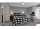 Well-lit bedroom featuring carpeted floors, a buffalo-checkered comforter, and a white desk by the bright window at 3341 Suffolk Ct, Greenwood, IN 46143