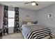 Stylish bedroom with window, floral curtains, ceiling fan, and striped bedding for a cozy feel at 3341 Suffolk Ct, Greenwood, IN 46143