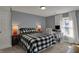 Well-lit bedroom featuring carpeted floors, a buffalo-checkered comforter, and a white desk by the bright window at 3341 Suffolk Ct, Greenwood, IN 46143