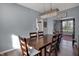 This dining room features a wooden table with seating for six under a modern chandelier at 3341 Suffolk Ct, Greenwood, IN 46143