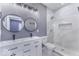 Modern bathroom with double vanity, round mirrors, and a tiled walk-in shower with a shower niche at 337 E Minnesota St, Indianapolis, IN 46225