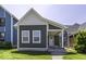 Charming home featuring a covered porch, gray siding and white trim and well-maintained front lawn at 337 E Minnesota St, Indianapolis, IN 46225