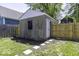 View of the backyard garage that has a window and a single door and is surrounded by a wooden fence at 337 E Minnesota St, Indianapolis, IN 46225