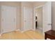 Hallway with hardwood floors, closet and bathroom access, and neutral paint at 350 N Meridian St # 205, Indianapolis, IN 46204