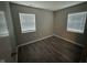 Bedroom with wood-look flooring and two windows overlooking the yard at 3519 N Whitcomb Ave, Indianapolis, IN 46224