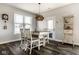 Cozy dining area featuring a rustic table, stylish lighting fixture, and large window at 3849 Sun Valley Dr, Westfield, IN 46074