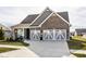 Charming home with a two-car garage, brick facade, grey siding, and a well-manicured front lawn at 3849 Sun Valley Dr, Westfield, IN 46074