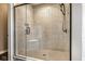 Shower featuring light stone-style tiles, glass door and corner shelf at 3849 Sun Valley Dr, Westfield, IN 46074