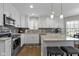 Modern kitchen with white cabinets, granite countertops, stainless steel appliances, and a kitchen island at 3856 Cornwallis Ln, Carmel, IN 46032