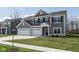 Charming two-story home with gray siding, black shutters, a three-car garage, and a lush green lawn at 4016 Railhead Ave, Westfield, IN 46074