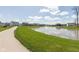 Scenic view of the community pond featuring a fountain, framed by vibrant green lawns and a smooth walking path at 4016 Railhead Ave, Westfield, IN 46074