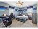 Comfortable bedroom featuring a gray bed, wall art, and a cozy corner for relaxation or hobbies at 4429 Serengeti Cir, Carmel, IN 46074