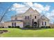 Beautiful two-story home with a stone and brick facade, manicured lawn, and professionally landscaped shrubs at 4429 Serengeti Cir, Carmel, IN 46074