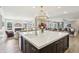 Open-concept kitchen with large island and modern lighting, seamlessly flowing into the living area at 4429 Serengeti Cir, Carmel, IN 46074