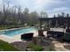 Inviting pool area with lounge seating, shade pergola, and a basketball hoop for recreation and relaxation at 4429 Serengeti Cir, Carmel, IN 46074