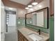 Bathroom vanity with granite countertop and large mirror, illuminated by modern lighting at 4744 Whirlaway Dr, Indianapolis, IN 46237