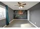 Bright bedroom featuring a unique floral accent wall, grey flooring, and a ceiling fan at 4744 Whirlaway Dr, Indianapolis, IN 46237