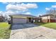 Charming single-story brick home featuring an attached garage, well-maintained lawn, and mature trees at 4744 Whirlaway Dr, Indianapolis, IN 46237