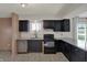 Well-equipped kitchen featuring dark cabinets, granite countertops, and stainless appliances at 4744 Whirlaway Dr, Indianapolis, IN 46237