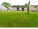 A spacious backyard featuring a well-maintained lawn and a modest home with a sliding glass door at 5446 Lippan Way, Indianapolis, IN 46221