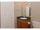 Well-lit bathroom featuring a green countertop, cabinet, mirror, and toilet at 5446 Lippan Way, Indianapolis, IN 46221