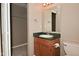 Well-lit bathroom featuring a green countertop, cabinet, mirror, walk-in closet, and toilet at 5446 Lippan Way, Indianapolis, IN 46221