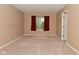 A spacious bedroom featuring neutral walls, carpet, and a window with red curtains at 5446 Lippan Way, Indianapolis, IN 46221