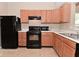 Kitchen features light wood cabinets, black appliances, and light colored countertops at 5446 Lippan Way, Indianapolis, IN 46221