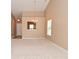 Inviting living room featuring neutral walls, carpeting, chandelier, natural light, and open entryway at 5446 Lippan Way, Indianapolis, IN 46221