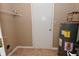 Compact utility room featuring a water heater, door to interior of house, and metal storage shelf at 5446 Lippan Way, Indianapolis, IN 46221