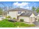 Back view of a well-maintained townhome featuring a lush green lawn and mature trees at 6059 S Bay Dr, Indianapolis, IN 46250