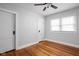 Bright bedroom with hardwood floors, one window, and a white door at 6158 Ralston Ave, Indianapolis, IN 46220