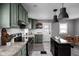 Updated kitchen with green cabinets, stainless appliances, granite counters, and a stylish center island at 6158 Ralston Ave, Indianapolis, IN 46220