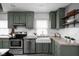 Charming kitchen with green cabinets, a farmhouse sink, stainless steel appliances and wood shelving at 6158 Ralston Ave, Indianapolis, IN 46220