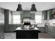 Kitchen with green cabinets, white backsplash, a black island and stainless-steel appliances at 6158 Ralston Ave, Indianapolis, IN 46220
