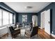 A living room featuring four gray chairs with wood trim, blue accent wall and hardwood flooring at 6158 Ralston Ave, Indianapolis, IN 46220