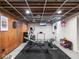 Spacious basement features workout equipment, wood paneling, and white brick walls at 645 N Ritter Ave, Indianapolis, IN 46219
