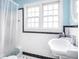 Classic bathroom with white tile, black trim, a bright window, and modern fixtures at 645 N Ritter Ave, Indianapolis, IN 46219