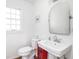 Cozy bathroom features updated sink, mirror, toilet, and window at 645 N Ritter Ave, Indianapolis, IN 46219