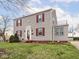 Two-story home with gray siding, red shutters, and a small balcony, complemented by a lush green lawn at 645 N Ritter Ave, Indianapolis, IN 46219