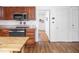 Kitchen view showcases microwave, oven, hardwood floors and a hallway leading to the bathroom at 645 N Ritter Ave, Indianapolis, IN 46219