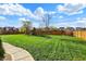 Large, manicured backyard featuring a playset, mature trees, and lush green lawn at 8107 Parcrest Ct, Indianapolis, IN 46259