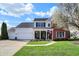 Charming two-story home with a well-manicured lawn, front porch, and attached two car garage at 8107 Parcrest Ct, Indianapolis, IN 46259