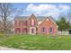 Charming two-story brick home with a well-manicured lawn, red shutters, and beautiful landscaping at 8414 Anchorage Ct, Indianapolis, IN 46236